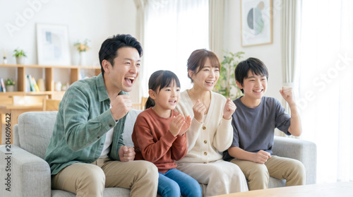 リビングのソファで動画や映画を見ておうち時間を楽しむ仲良し家族