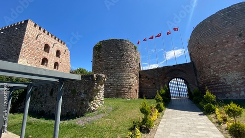 Front entrance of the historic Eskihisar Castle in Gebze, Kocaeli, Türkiye, featuring its ancient stone towers under a clear blue sky.
