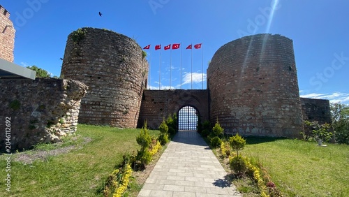 Front entrance of the historic Eskihisar Castle in Gebze, Kocaeli, Türkiye, featuring its ancient stone towers under a clear blue sky.