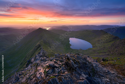 Foto Dramatic colourful sunrise over Helvellyn overlooking Swirral Edge and Red Tarn in The Lake District mountains