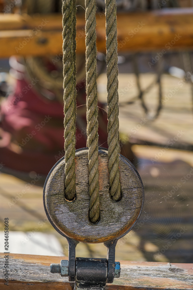 Obraz premium Close-up of a pulley on an old sailing ship in a harbor on the Baltic Sea.
