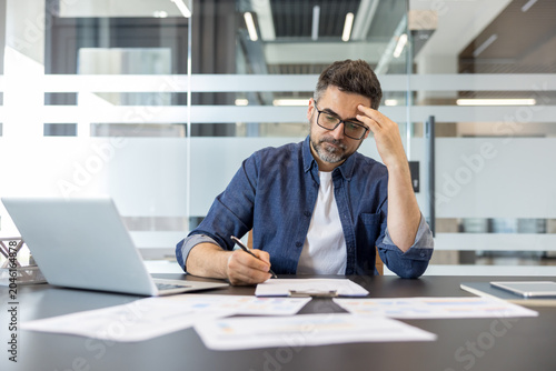 Cuadro en lienzo Tired businessman feeling overwhelmed with work, experiencing a headache and str