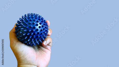 Принти на полотні Hand holding a blue spiky tactile ball for physical therapy and muscle relief