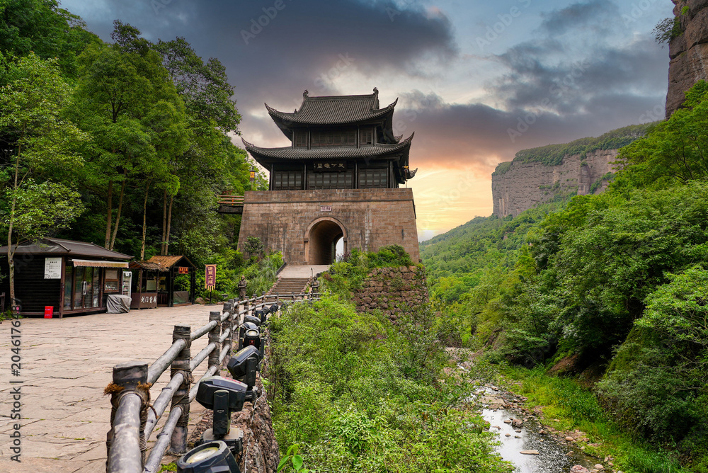 Obraz premium Ancient Jianmen Guanlou gate tower surrounded by steep mountain cliffs in Jianmen Pass, Sichuan, China
