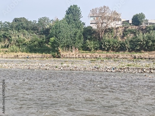 Foto A wide, freshwater river winds its way through a vast landscape of gray gravel and sandy stone banks