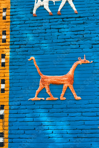 Vibrant wall mural featuring orange dog artwork in Babylon Iraq showcasing local culture