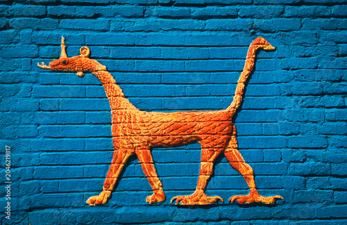 Ancient creature mural on blue wall in Babylon, Iraq showcasing historical artistry