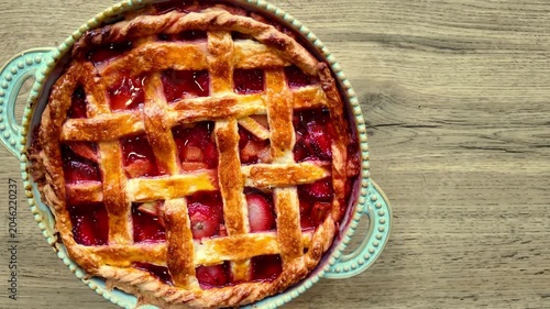 Homemade strawberry rhubarb pie rotating top view fresh baked dessert pastry sweet fruit tart rustic bakery