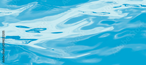 Obraz na plátně Close-up of blue water surface with subtle ripples and reflections, capturing a