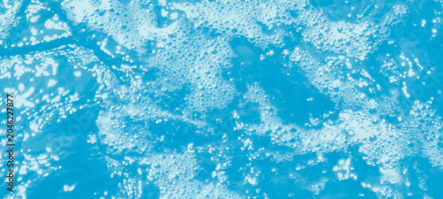Fotografie Dynamic blue water surface with abundant small white bubbles and light reflectio
