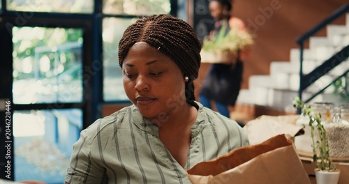 Foto Buyer enjoying fresh smell of locally grown lemons from farm, smelling citric aroma and putting ecological fruits in a bag