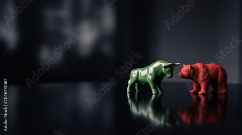 Bull and Bear Market Concept with Figurines on Reflective Surface.