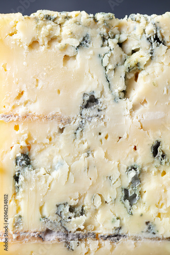 Macro texture of gourmet blue cheese with noble mold veins and creamy surface. Close up background.