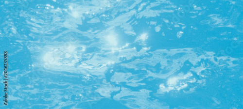 Obraz na płótnie Sparkling water surface of swimming pool with bright sunlight glares creating sh