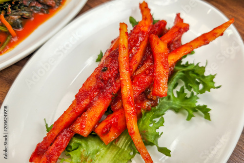 Spicy seasoned deodeok root salad served as a traditional Korean side dish, featuring fresh mountain vegetable flavors and authentic Korean cuisine.