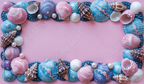 Seashell and pearl decorative frame in vibrant blue and pink hues on a soft pink background, perfect for ocean-themed designs.
