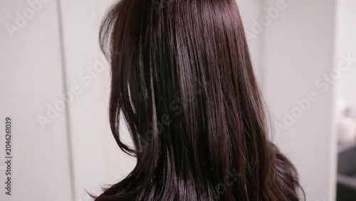 Close-up of a woman's long, dark brown hair, showcasing its healthy shine and texture, ideal for beauty, haircare, and lifestyle concepts.