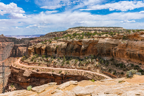 фотографія A tight hairpin switchback of the Shafer Trail hugs a sheer red sandstone cliff above a deep canyon at Canyonlands Island in the Sky, Utah
