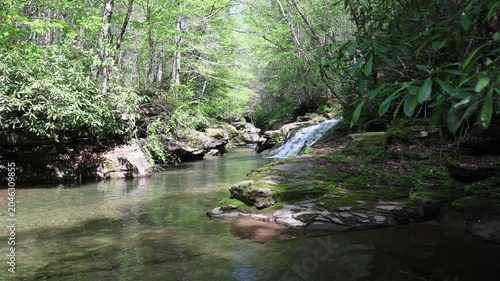 Water cascades down a picturesque waterfall where remote rivers join.  Rock ledge in the foreground.