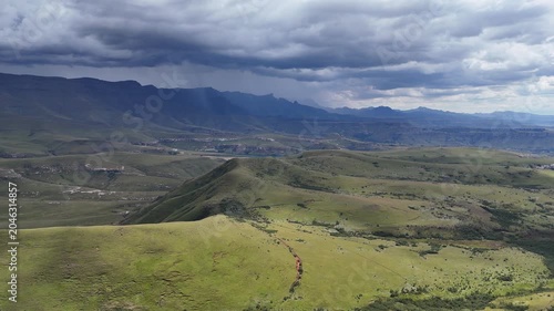 Stormy Aerial View Drakensberg Green Valley Under Brooding Clouds, Winding Dirt Track Cutting Through Rolling