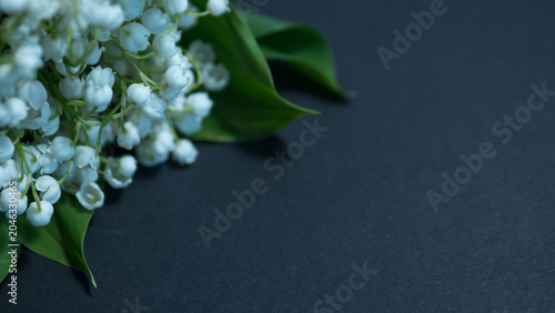 Foto Lily of the valley bouquet close up with white blossoms and green leaves on dark