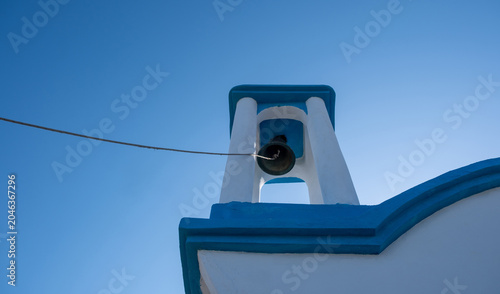 Foto Blue and white Orthodox church bell tower from low angle in Ikaria island, Greec