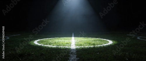 Empty soccer field center circle illuminated by dramatic spotlight at night