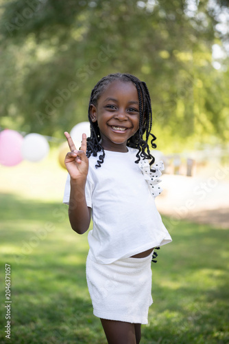 Foto Little african american girl smiling showing peace sign