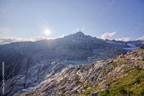 Sunlit mountain peaks with cloudy sky