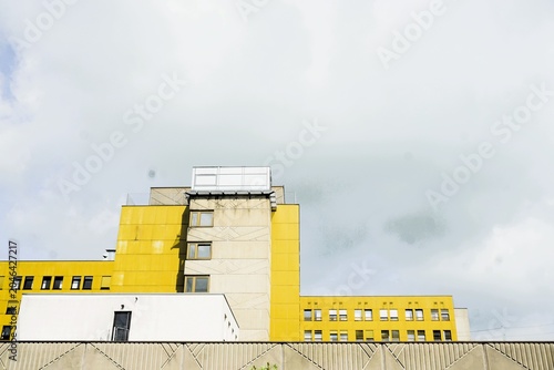 Beige-gelbes Krankenhaus vor grauem Himmel 