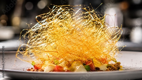 Macro close-up of golden spun caramel sugar threads for fine pastry decoration