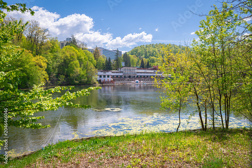 Foto Peaceful lakefront pavilion surrounded by forest trees on a sunny spring day at