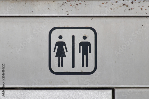 Minimalist gender sign on a metallic wall