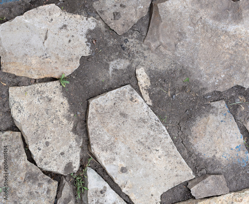 Rough grey stones with soil and painted fragment