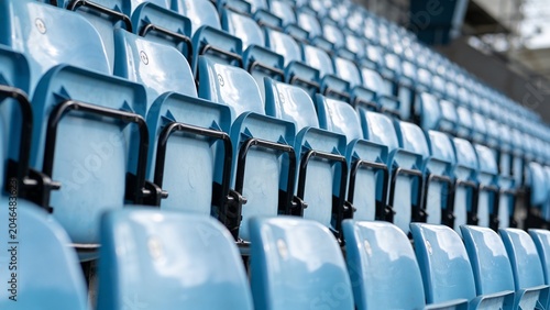 Rows of Empty Light Blue Plastic Seats in a Sports Stadium, Close Up Diagonal Perspective of Vacant Bleachers