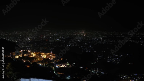 Night timelapse view of Dehradun city captured from the hills of Mussoorie, Uttarakhand, India. Long exposure light trails and vibrant illumination highlight the dynamic energy of the city at night.