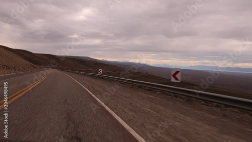 Slow-motion video taken from a moving car traveling along a high stretch of Route 40 in Argentina, where desert hills can be seen.