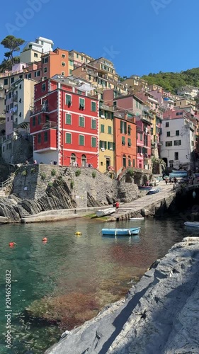 Exploring Riomaggore in Italy with colorful buildings and boats under the blue sky