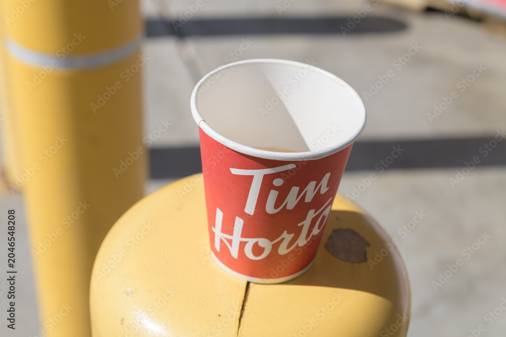 Obraz premium discarded Tim Hortons beverage cup on a safety barrier post, Toronto