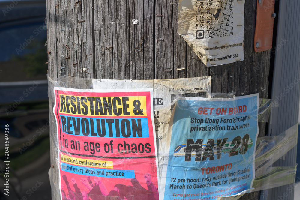 Naklejka premium street posters stapled to a wood pole in Toronto (protest)