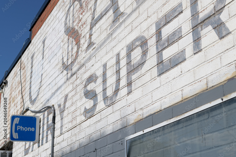 Naklejka premium old phone sign and retro painted wall sign outside S&A Variety Store, a convenience store, located at 128 Pritchard Av, northeast corner of Jane St, Toronto