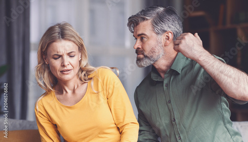 Photos Angry Emotion Displayed By Upset White Male And Female, Engaging In Argument At Home, Sitting On Couch