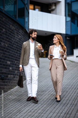 Принти на полотні Business people walking and talking outdoors during coffee break