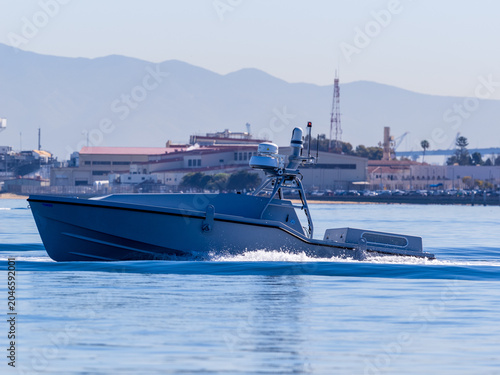 Fotografía Unmanned Surface Vessel Underway on Open Water Near Coastal Facility