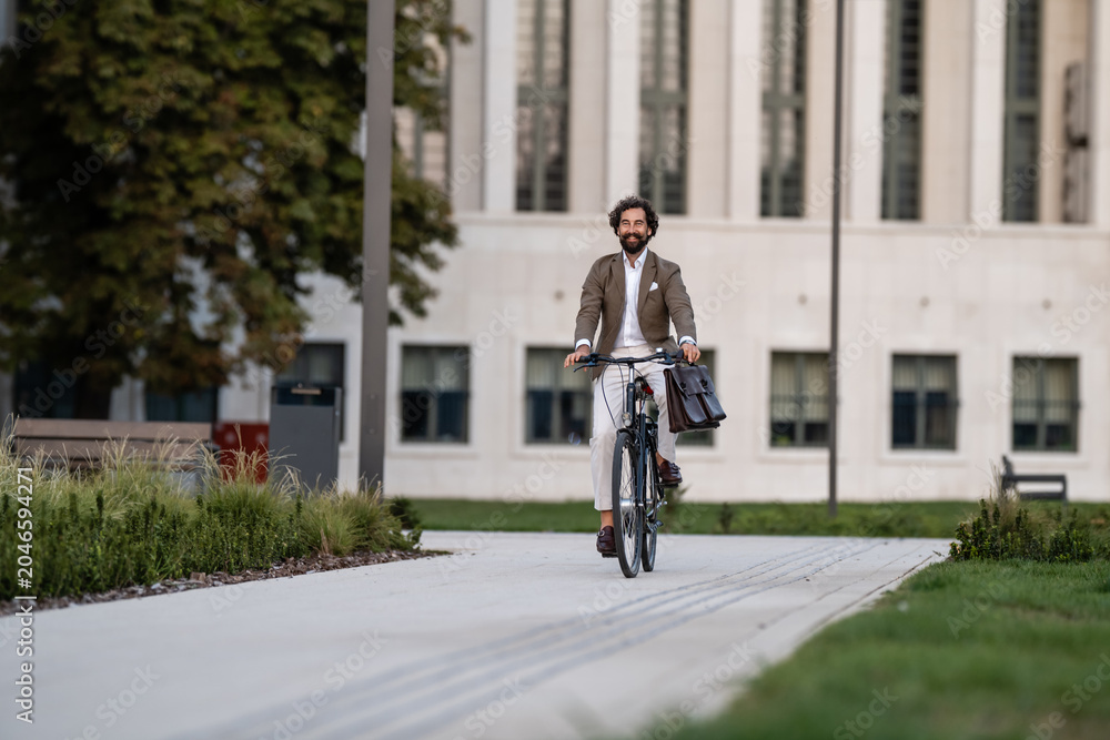 Naklejka premium Businessman riding bicycle in urban setting, promoting sustainable commuting