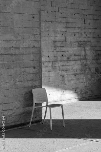 Foto Single Modern Chair Against Concrete Wall in Black and White