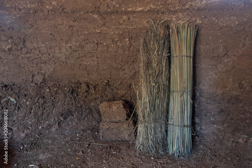 Interior of earthen hut with primitive rolled mats