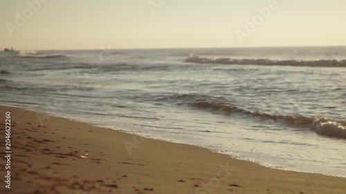 Small sea wave, Blurred Soft foamy waves washing golden sandy beach on dawn. Ocean Waves On Sandy Beach. Nobody. Holiday recreation concept. Abstract nautical summer ocean sunset nature background.