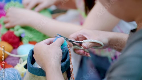 Hands Cutting Colorful Yarn During Handmade Textile Workshop