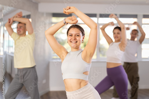 Foto Smiling sporty active young girl enjoying contemporary vigorous dance at group c